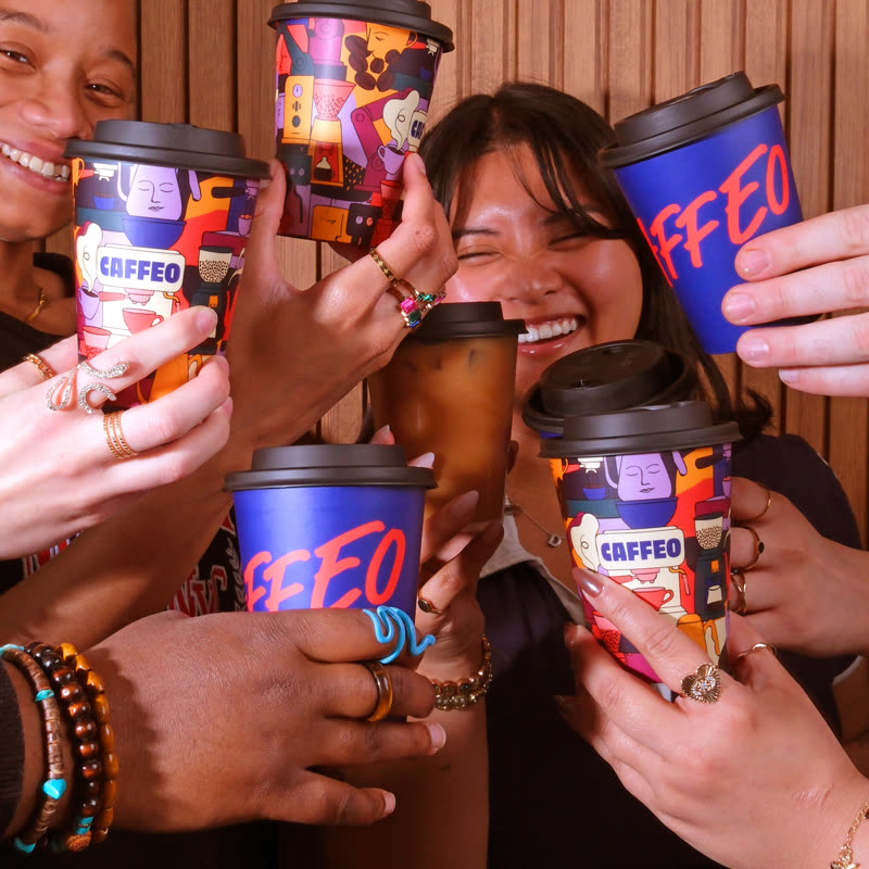 Four friends clinking patterned Caffeo cups together